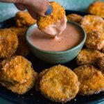 Air Fried Pickles being dipped into a pot of sauce.
