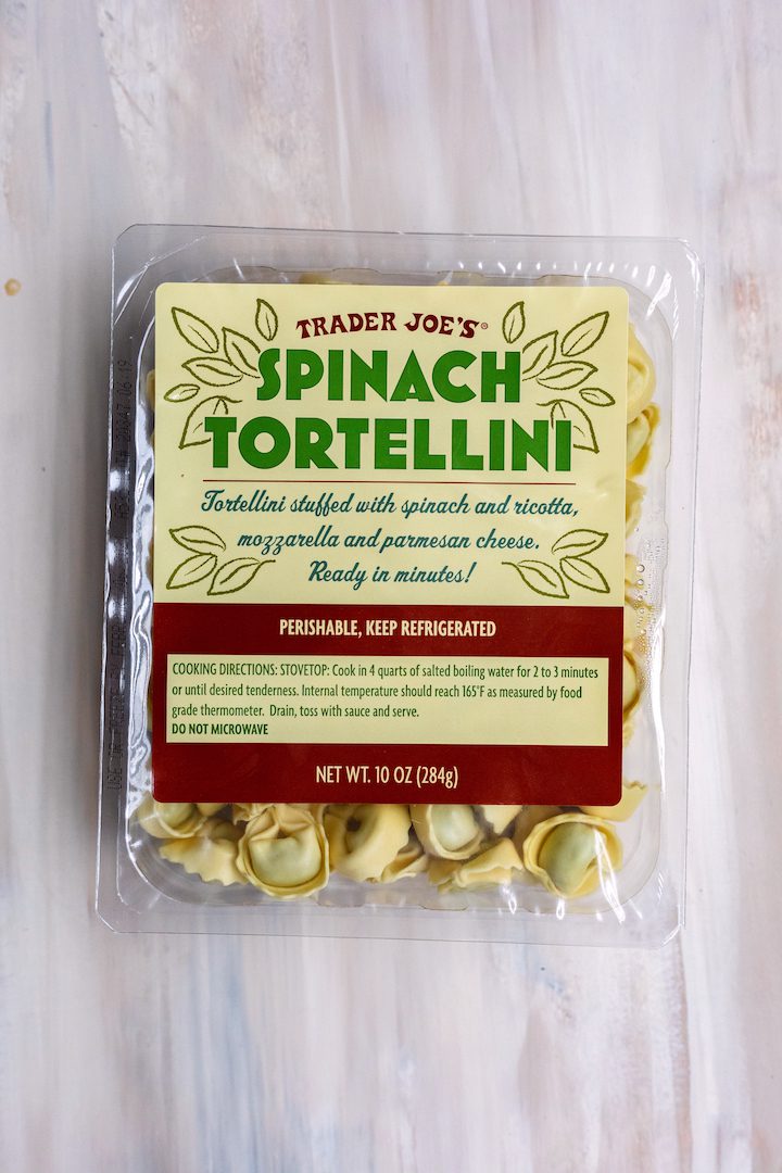 Packet of Trader Joe's Spinach Tortellini on a light wood background.