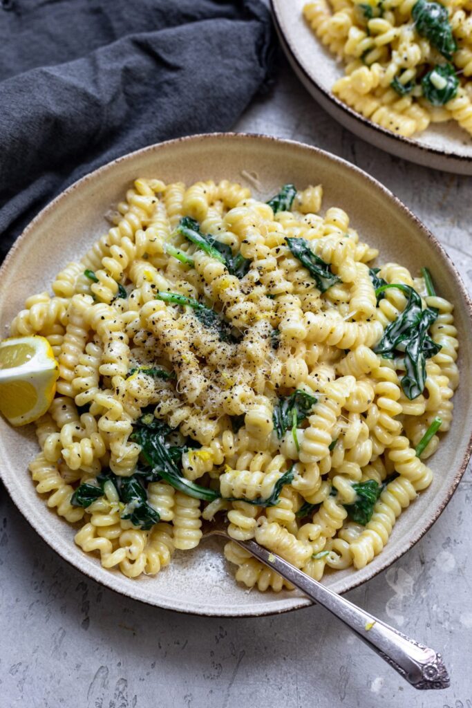 Creamy pasta with spinach and lemon topped with parmesan and fresh chopped parsley.